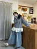 Foto real del atuendo en capas de otoño 2026: conjunto de tres piezas para mujer: camisa de cuadros estilo patchwork + chaleco de punto + falda midi