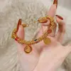 Pequeno livro vermelho de alta luxúria explosões ouro real 24K galvanoplastia Wei Xue com esmalte amarelo deus da riqueza deus da riqueza de cinco caminhos mãos envolvidas
