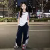Nuevo Conjunto Deportivo Casual de Verano Elegante para Niñas y Niños Medianos/Mayores, Conjunto de Dos Piezas a Rayas de Manga Corta y Pantalones Largos Estilo Coreano Chic