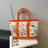Moderna y Linda Estilo Coreano 2025 Nueva Bolsa de Hombro Tote de Gran Capacidad con Estampado de Graffiti de Dibujos Animados Elegante para Salir