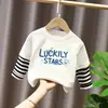 Camiseta de manga larga de algodón puro para niño 2026 primavera y otoño nueva elegante de dibujos animados estilo dos piezas falsas camiseta base de primavera para niño