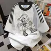 Novos Tops Soltos de Manga Curta com Costura de Três Listras para o Verão de 2025, Camisetas Masculinas e Femininas Personalizadas Ins High Street com Estampa de Letras