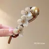 Elegante pinza para el pelo de cuentas florales retorcidas para mujer, nuevo accesorio para el pelo de recogido en la nuca de alta gama 2026