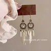 Pendientes largos con borlas y plumas en forma de gota de agua para mujer, estilo bohemio, con cuentas de arroz, estilo europeo y americano, accesorios de turismo y vacaciones.