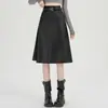 Foto real de falda de mujer de cuero PU negro, nuevo modelo otoño 2026, de cintura alta, adelgazante, corte holgado, elegante falda de paraguas línea A, falda midi