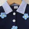 Atacado transfronteiriço de roupas para meninas: camisas com estampas florais, saias curtas listradas e blusas estilo preppy