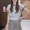 Tejido de punto con manga corta abotonada y dobladillo de color contrastante para mujer 2026 Nuevo estilo coreano de verano Diseño irregular Top corto