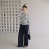 El nuevo top de Lyocell para principios de otoño presenta un diseño a rayas de un solo hombro, mangas largas y una cintura ajustada que acentúa la figura.