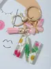 Suministros del Fabricante Llaveros con Flores Secas Prensadas 26 Letras del Alfabeto Inglés Llaveros con Borla de Mariposa Charms para Bolsos de Mujer