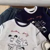 Camiseta de algodón puro para niños, modelo primavera y otoño 2026 para bebés y niños pequeños, top de dibujos animados graffiti estilo ins, camiseta interior de manga larga para niños