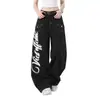 Jeans de mezclilla estilo high street americano con estampado de alas graffiti y costuras visibles, corte holgado para hombre, pantalones de pierna ancha de diseño único para trabajo