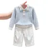 Ropa infantil coreana 2026 otoño e invierno nuevo suéter de punto de manga larga a rayas azules con cuello polo y pantalones rectos casuales para niños
