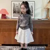 Ropa infantil estilo coreano 2026 colección otoño e invierno nueva: conjunto de moda para niñas: cárdigan de punto gris dulce con lazo y falda blanca a media pierna
