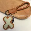 Venta al por mayor transfronteriza de llaveros japoneses y coreanos con letras en inglés, dijes para bolso de cuero dopamina, pequeños accesorios y regalos