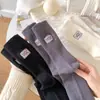 Calcetines de cachemir otoño e invierno nuevos ins marca de moda calcetines terciopelo australiano letras bordadas letras MU X color sólido calcetines de tubo versátiles
