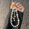 Elegante pulseira de celular flor de ameixa de cristal com laço cravejado de strass e franja, acessório de bolsa de pulso curto