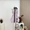 Top sin mangas y falda con bloques de color morado satinado uva y lazo con volantes