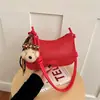 Bolsa de Cor Sólida com Textura Trançada Feminina Outono 2026 Nova Bolsa de Ombro Único Moda Bolsa de Mão Bolsa Transversal de Grande Capacidade Pingente