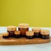 Garrafa de creme de chá com tampa de bambu e madeira Garrafa de cosméticos portátil Creme corporal Creme para os olhos Creme para o rosto Garrafa de vidro à prova de luz Atacado