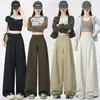 Foto real de calças casuais de perna larga com corte curvo, versátil e que afina a silhueta para mulheres, finas, largas, fluidas, estilo workwear, calças de secagem rápida, primavera/verão 2026