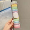 El cabello de la niña está recogido con gomas elásticas que no dañan el cabello, las gomas para el cabello de las niñas no restringen y no dejan marcas, accesorios para el cabello duraderos para niños