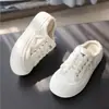 Chinelos Meio Sapatos com Biqueira de Lona para Uso Externo Feminino Outono 2025 Novos Sapatos Brancos Sem Salto Sandálias Respiráveis com Solado Grosso para Mulheres