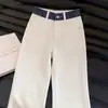 Calça jeans branca para homens, com patchwork de estampa de cobra em cores contrastantes, bainha dobrada, estilo vibe americana, design único e levemente alargada.