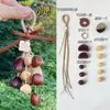 Kit de material DIY para fazer um móbile de casca de fruta, um sino pendurado de cura, com frutas pretas indonésias, estramônio, lírio d'água e rotim