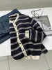 Um cardigã de tricô listrado azul marinho, estiloso e retrô, para mulheres, perfeito para a primavera e o outono. Possui um tecido macio e amigo da pele, um design vazado, decote redondo e detalhes de botões.