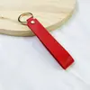 Llavero de PU de color sólido transfronterizo creativo de color caramelo banda ancha de cuero cuerda para la mano simple para llaves de coche de hombre venta al por mayor