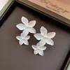 Brincos de Botão Flor Plissada de Metal Prateado Cruzados Europeus e Americanos Simples Modernos para o Dia a Dia Brincos de Luxo Leve com Sensação de Alto Padrão Acessórios de Brincos para Mulheres