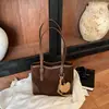 Nova bolsa tote estilo coreano 2026 para meninas, grande capacidade, bolsa de ombro único, com um chaveiro de urso de desenho animado fofo, versátil para o uso diário