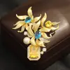 Elegante y lujoso broche vintage de alta gama con incrustación de piedra azul y diseño de crisantemo en oro cepillado, un accesorio sofisticado para mujeres