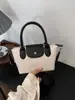 Bolso de hombro de nailon simple color block, bolso con forma de dumpling, versátil para primavera y verano, un bolso de mano de nicho y elegante con una textura de moda