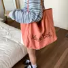 Bolsa de Lona com Letra Estilo College para Mulheres 2025 Nova Tendência Moda Estilo Coreano Bolsa Tote Casual Grande Capacidade Bolsa de Compras