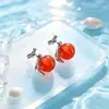 Brincos vibrantes de ágata na cor pêssego, criando uma atmosfera suave e charmosa, perfeitos para meninas. Estes brincos simples, porém elegantes, estão disponíveis para atacado