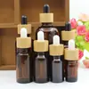 Botella de vidrio ámbar para aceite esencial 5-100 ml botella para mezclar esencia de cuidado de la piel anillo de bambú gotero con cabeza de goma botella vacía para subenvasado