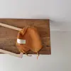 Chapéu de tricô infantil estilo coreano para outono e inverno com cadarços, cores vibrantes da moda, chapéu redondo fofo e versátil com proteção para as orelhas