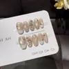 Pacto de Café con LecheUñas postizas francesas hechas a mano de un blanco lechoso suave con estampados en inglés y textura de concha triturada, ofreciendo una vibra dulce y fresca