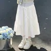 Conjunto de moletom e saia de duas peças com retalhos listrados em estilo preppy para meninas, com um doce design de laço, perfeito para primavera e outono.