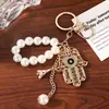 Llavero del Mal de Ojo con Cadena de Perlas de Imitación y Colgante de Palma Tachonado de Diamantes, Colgante Azul para Bolso de Mujer, Pequeño Regalo