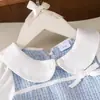 26 Exclusivo transfronterizo para niñas: Nueva colección de primavera y otoño, con un lindo cuello de muñeca, estampado de cuadros azules y blancos, y un dulce vestido de manga larga inspirado en el estilo Chanel.