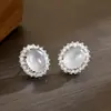 Aretes de botón ovalados transparentes como el hielo con luz solar para mujer, completamente incrustados con diamantes, delicados y versátiles para primavera y verano, creando un look atmosférico