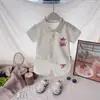 Traje de Verano para Niños 2026 Estilo Nuevo para Niños y Niñas, Estilo Bebé Dibujos Animados Botonadura Manga Corta Pantalones Cortos Conjunto Deportivo de Dos Piezas