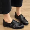 Mocasines de piel con tacón grueso de estilo francés, con un diseño inspirado en el británico, un detalle de hebilla y un tacón bajo, lo que facilita ponérselos y quitárselos.