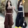 Conjunto de otoño para niñas 2026 nuevo modelo conjunto de dos piezas de imitación con top de retazos a rayas y pantalones cargo para niños venta al por mayor