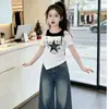 Camiseta de Manga Corta con Hombros Descubiertos y Estampado de Estrellas Dulce y Fresca para Niñas 2026 Nuevo Estilo Coreano de Verano Chica Popular Estilo Universitario Streetwear Ropa para Niños