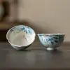 Taza de té de porcelana azul y blanca pintada a mano con esmalte debajo, featuring un pez jugando con una flor de loto, una nueva taza de té kung fu de estilo chino