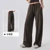 Calça esportiva casual feminina de corte solto com bolsos laterais, cintura elástica com cordão, design de perna larga, adequada para treinamento de Pilates e fitness