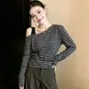 Camiseta de rayas off-shoulder de manga larga para mujer, nuevo estilo de principios de otoño, corte ajustado, que realza la figura, con un diseño asimétrico, perfecta como capa base